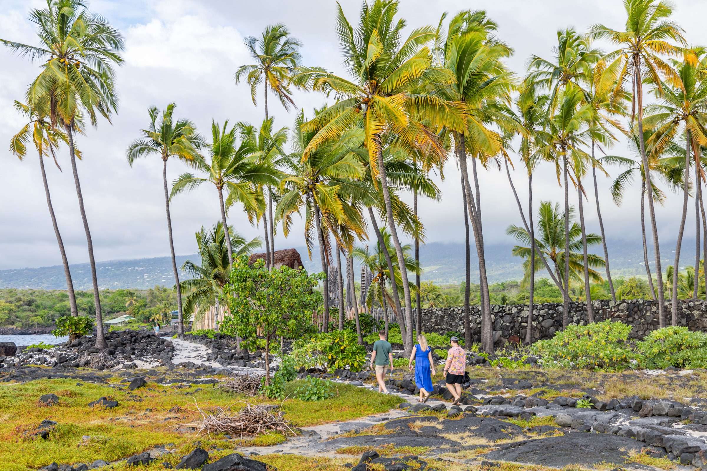 Kona shore excursion guests walking along the ancient Hawaiian trail in Pu'uhonua O Honaunau National Historical Park.