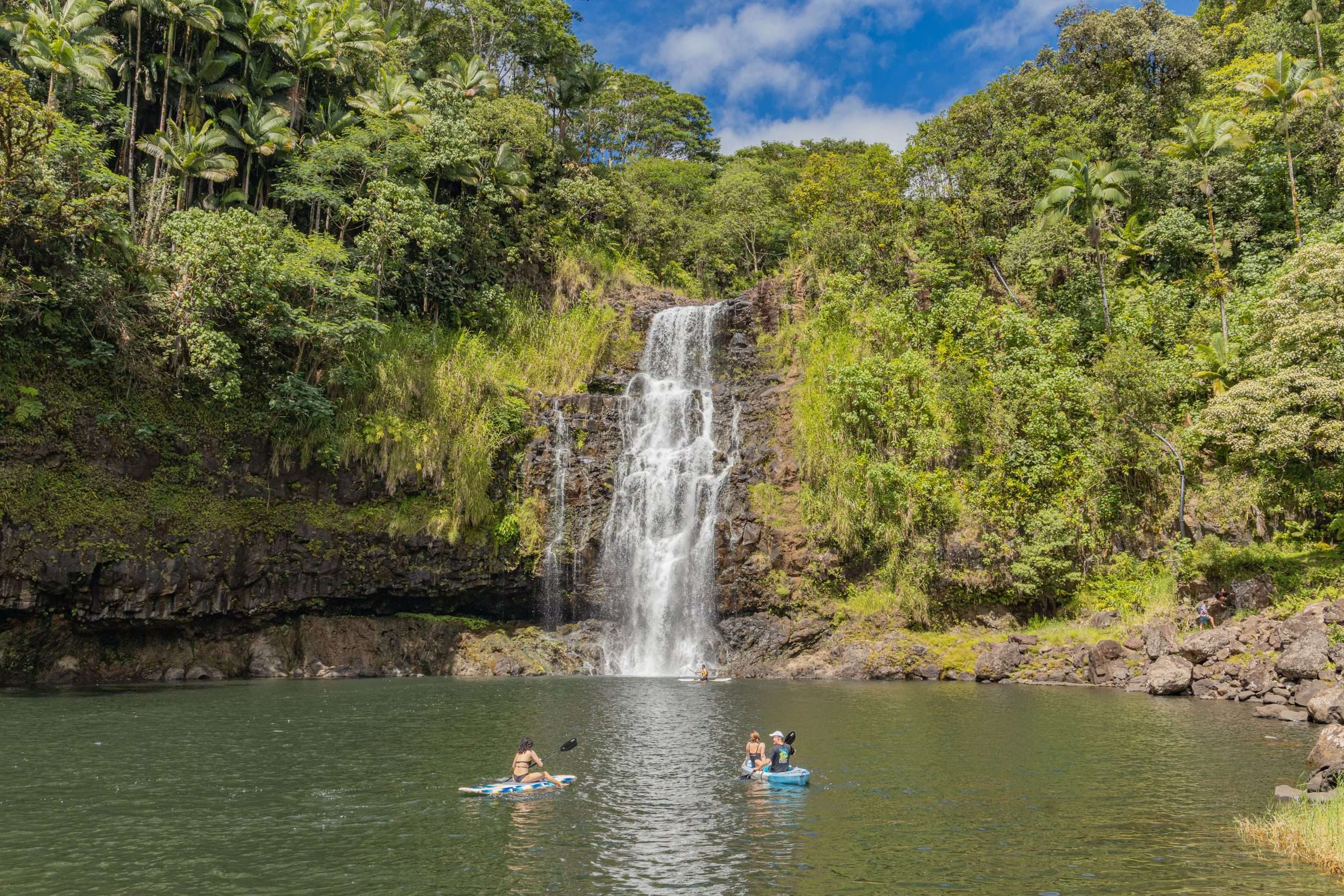 Kona waterfall tour guests paddle boarding at Kulaniapia Falls.