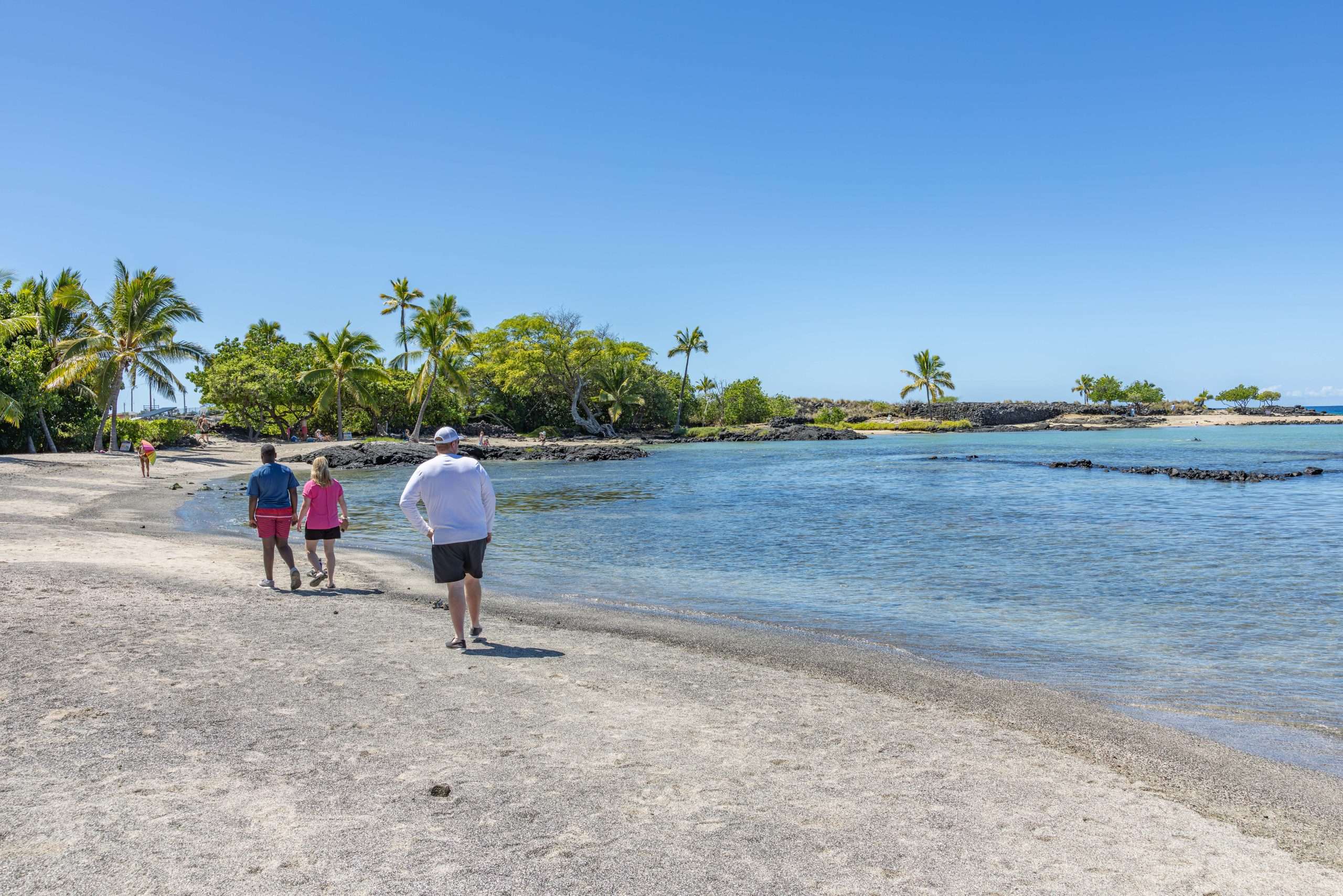 Kona cruise tour guests strolling along beach at Kaloko-Honokohau National Historical Park.