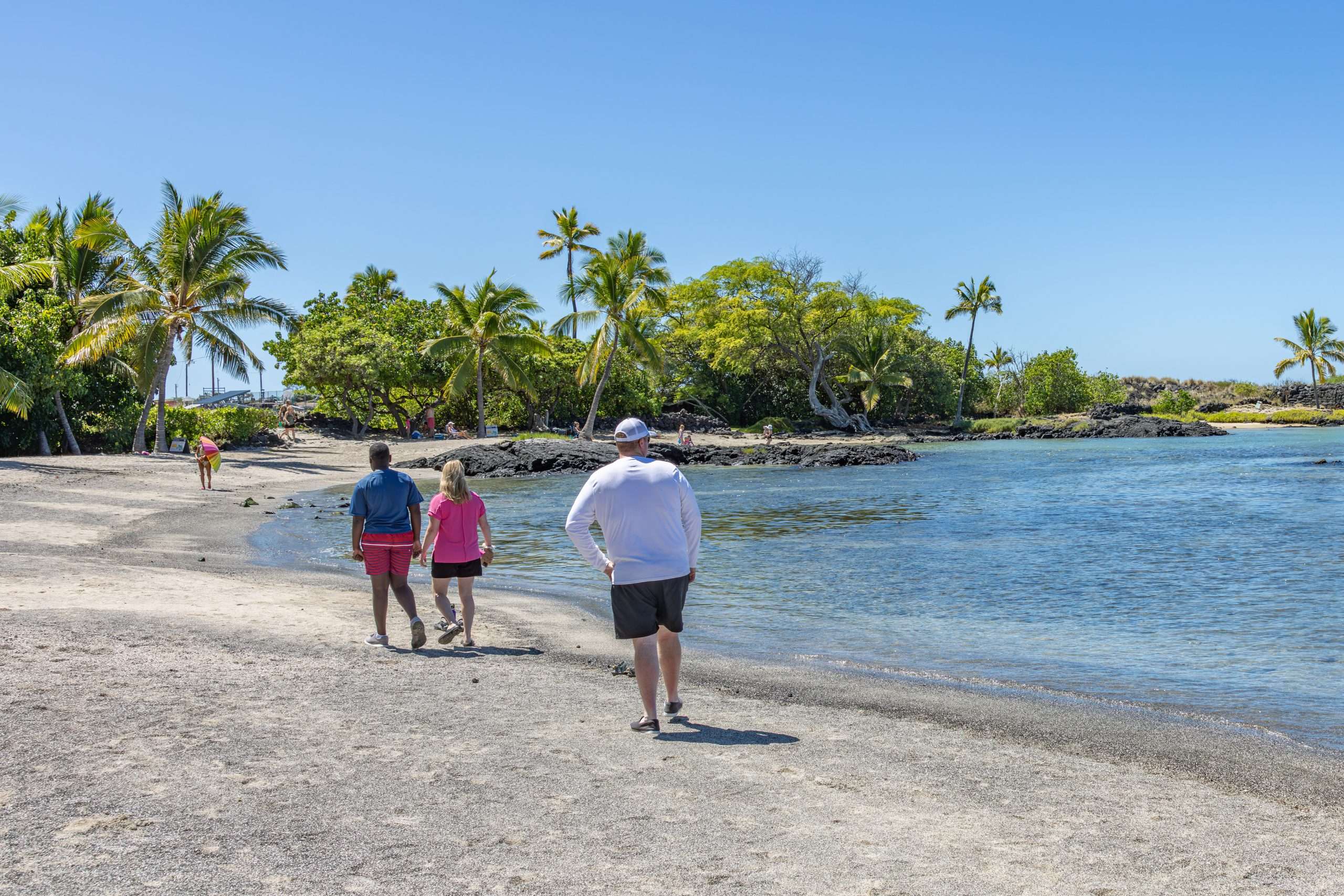 Family walks on beach at Kaloko-Honokōhau National Historical Park.