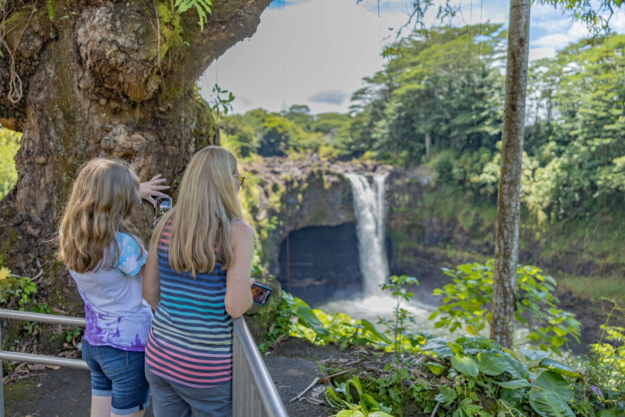 Big Island circle tour guests taking a photo at Rainbow Falls.