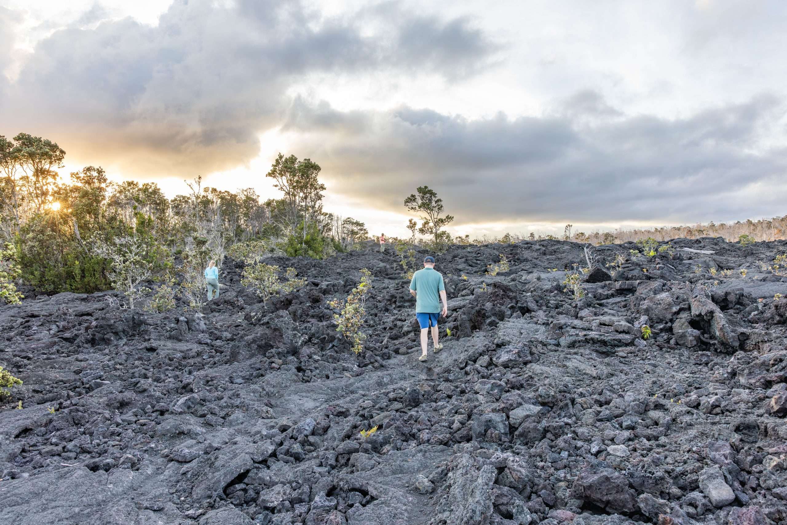 Volcano tours Hawaii guests walking through lava field in Volcanoes National Park.