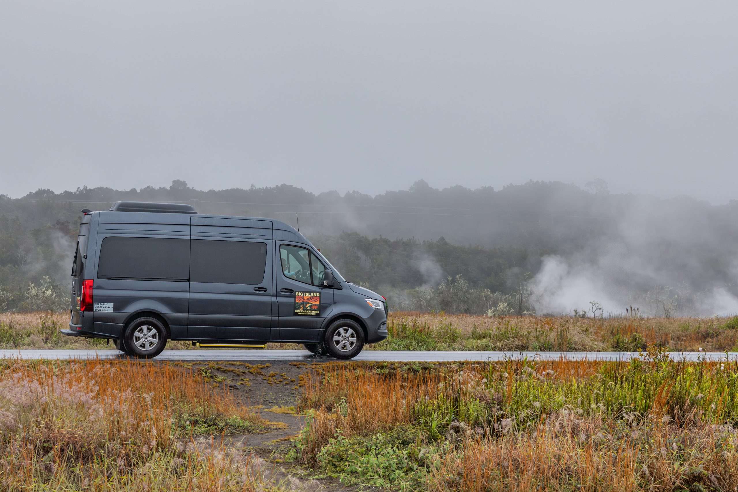 Big Island Backroad Adventures tour van driving past steam vents in Hawai'i Volcanoes National Park.