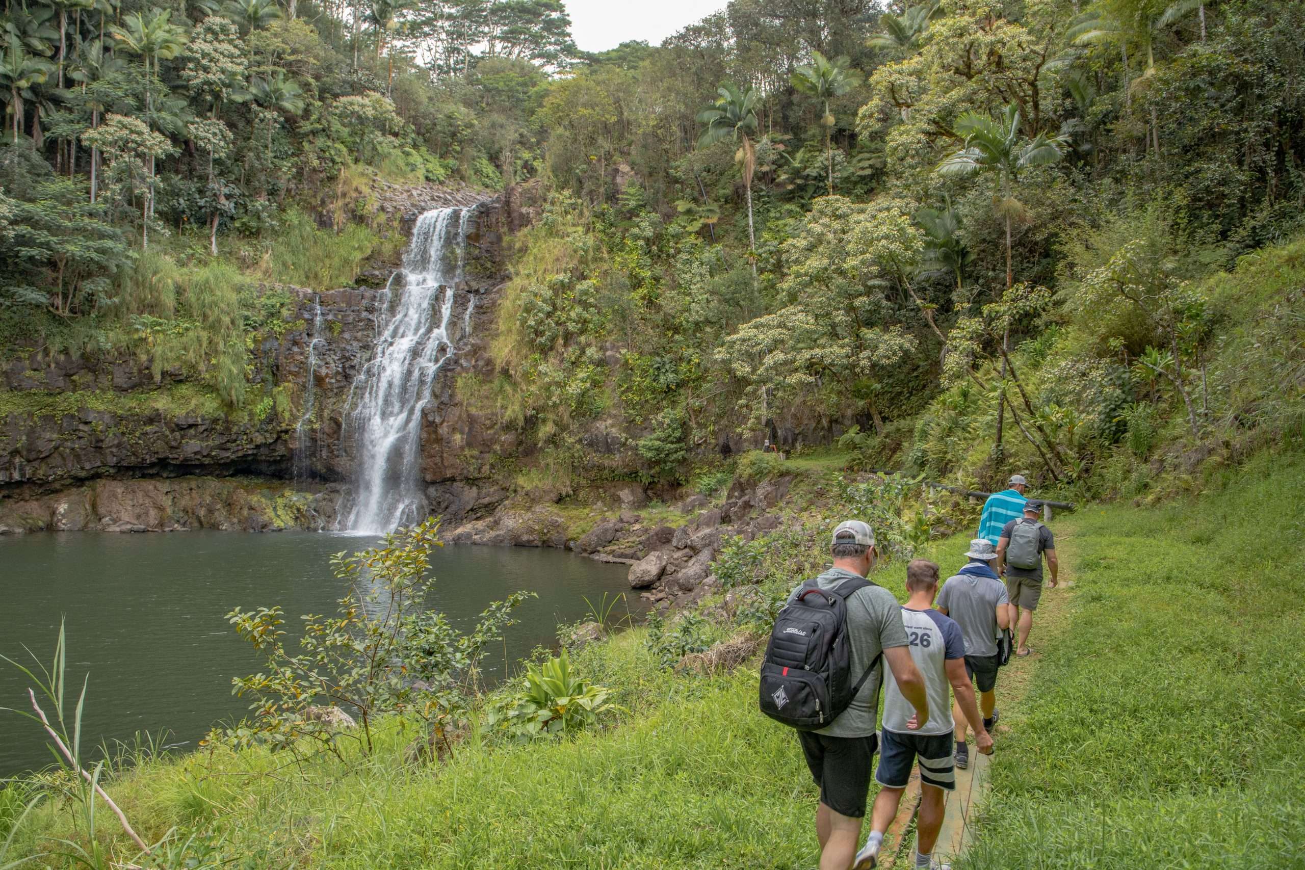 Big Island waterfall tour guests walking around Kulaniapia Falls.