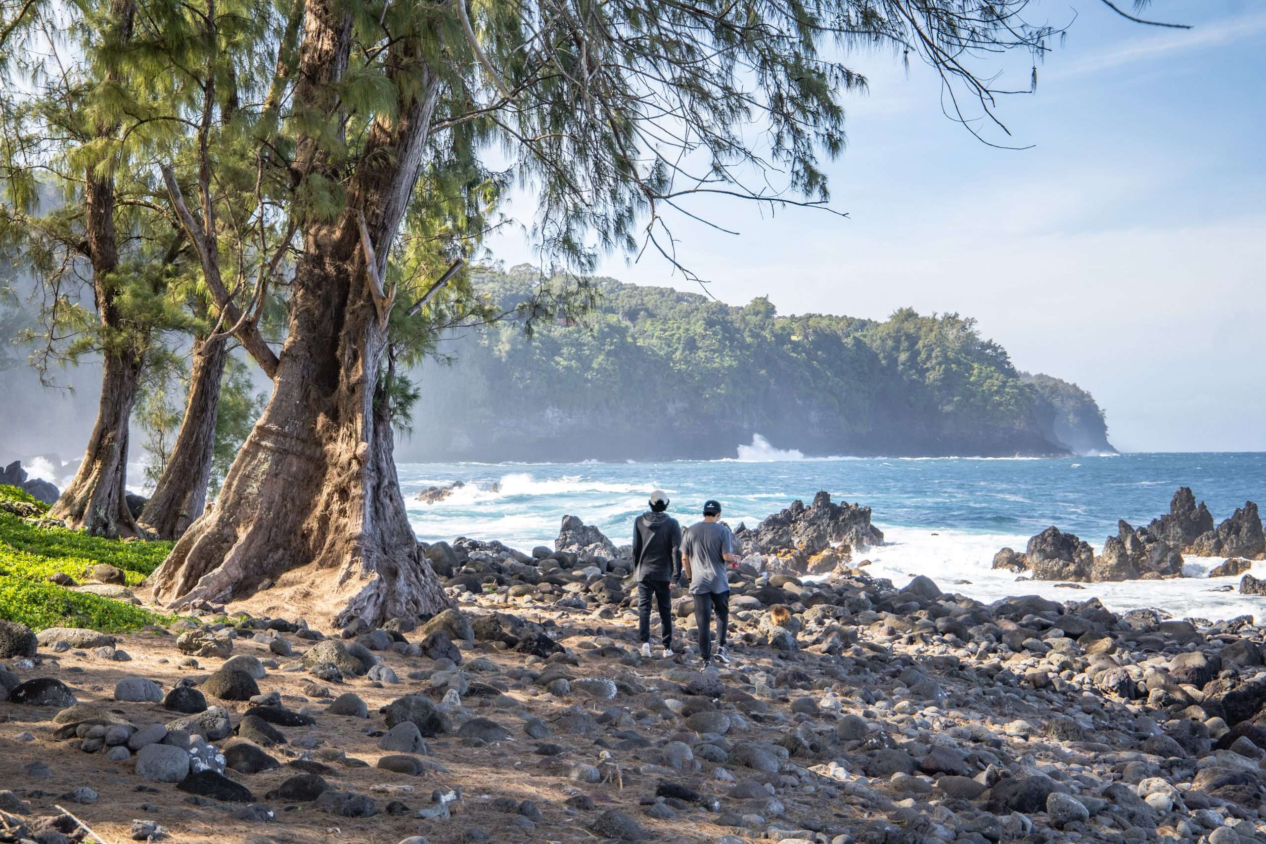 Guests walking along shoreline at Lapahoepahoe beach park, best tours on the Big Island.